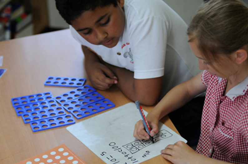 Children engaged in hands-on maths learning with colorful Numicon shapes